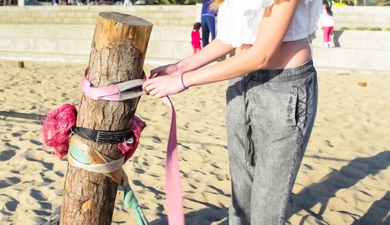 Chica desmontando una cinta de slackline