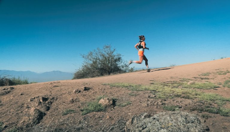 Trail runner mujer en el cerro entrenando